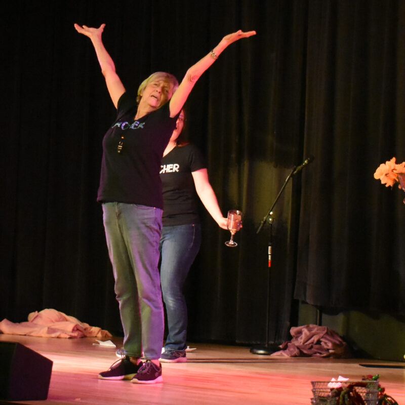 group of performers on a stage holding props