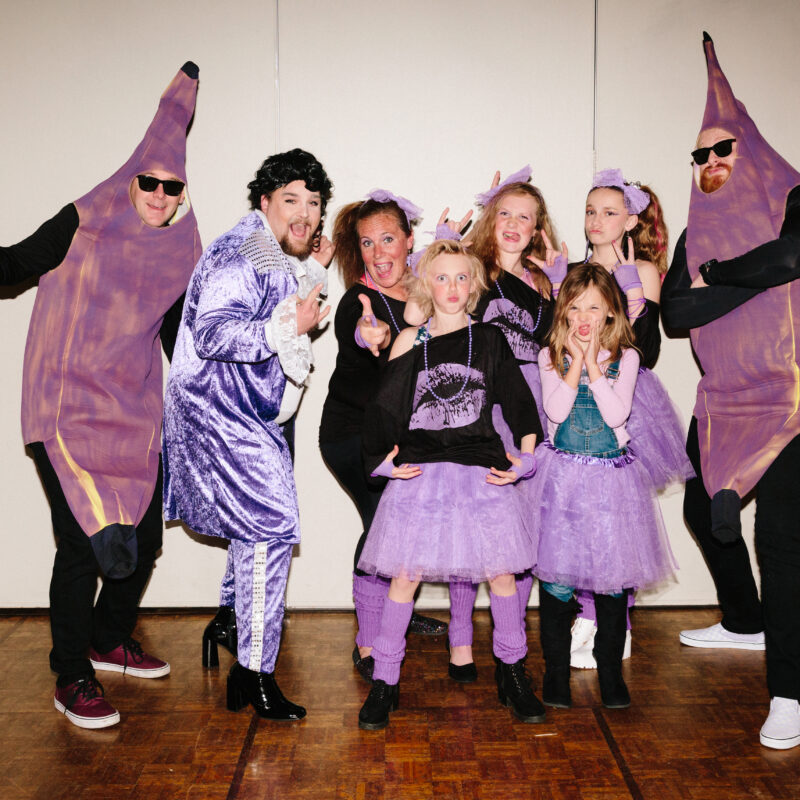 group of people dressed in purple and black