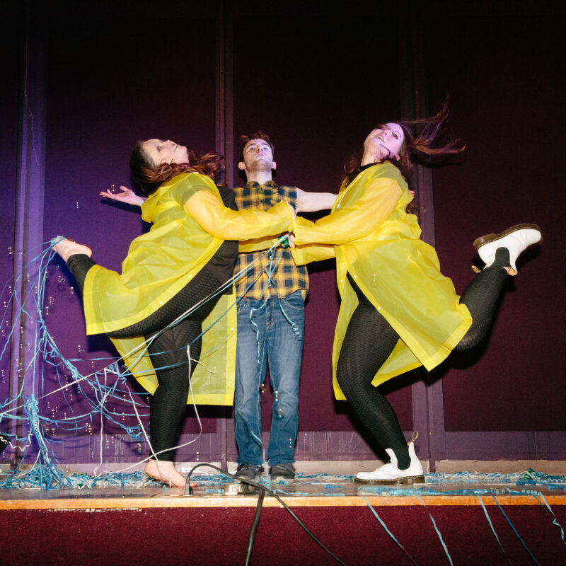 three performers on a stage dancing in confetti