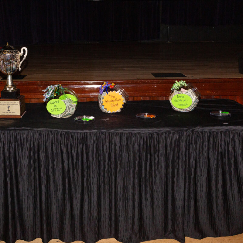 three fundraising jars and a trophy on a table